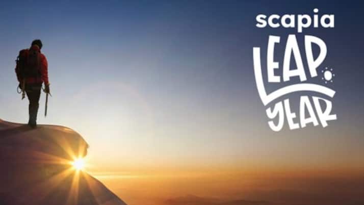 A traveller stands at the edge of a peak as the sun rises — symbolising Scapia’s Leap Year initiative, a year-long, fully funded journey designed to inspire exploration, growth, and self-discovery for young Indians.